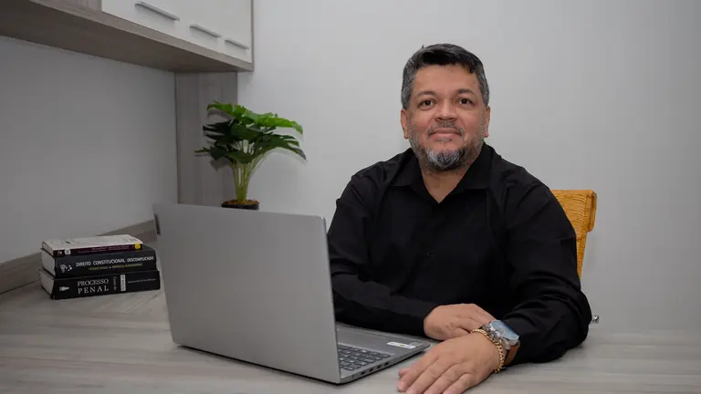 Doutor Jocinei Costa sentado à mesa de trabalho no escritório em Sorriso-MT