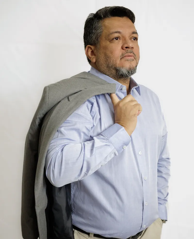Doutor Jocinei Costa de camisa social com o paletó apoiado no ombro