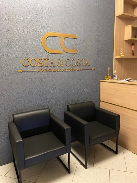 Recepção do escritório Costa & Costa Advogados Associados com a logomarca na parede